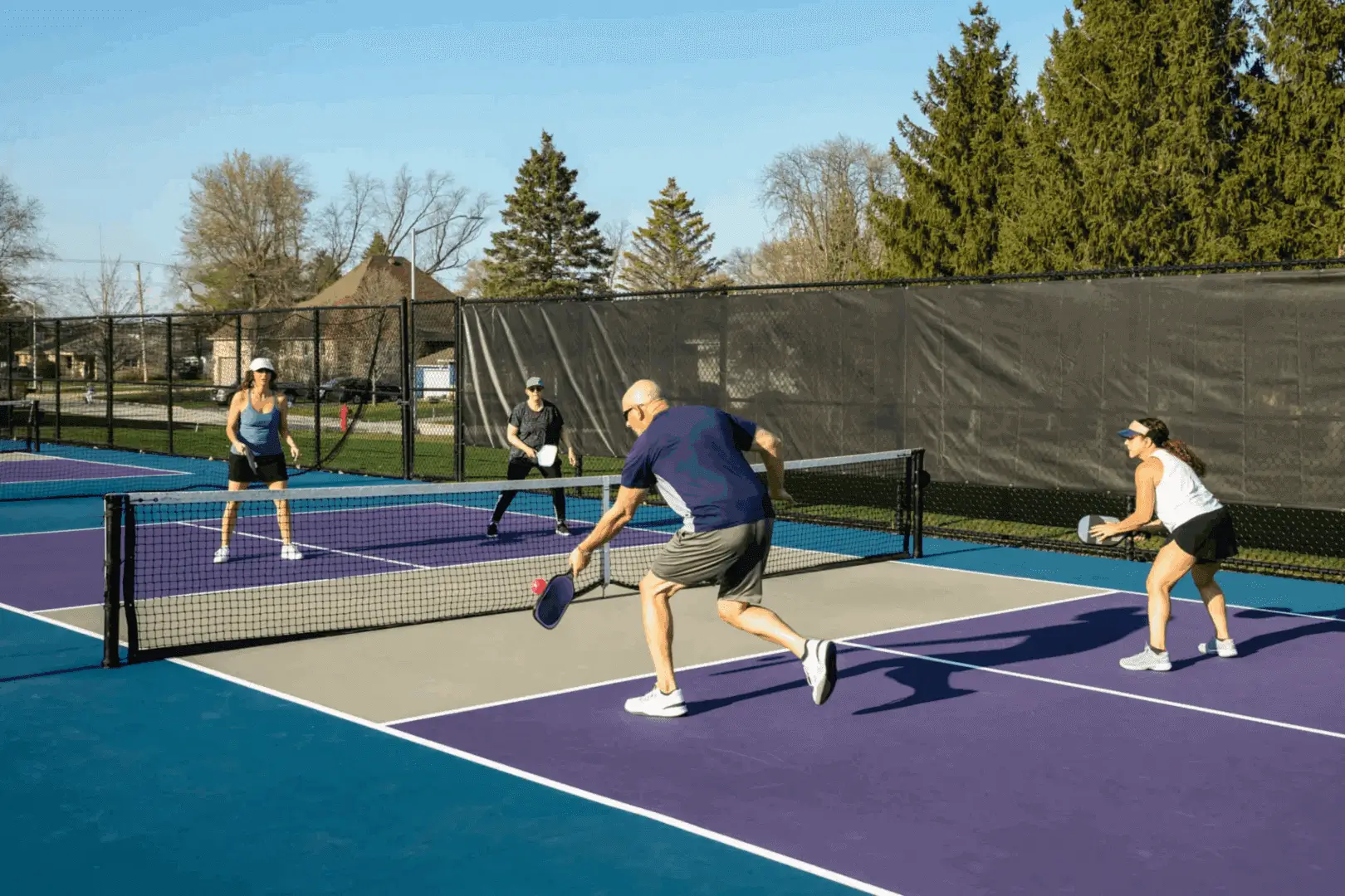 A group of people playing tennis on a court.